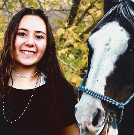 Breanna standing with a horse
