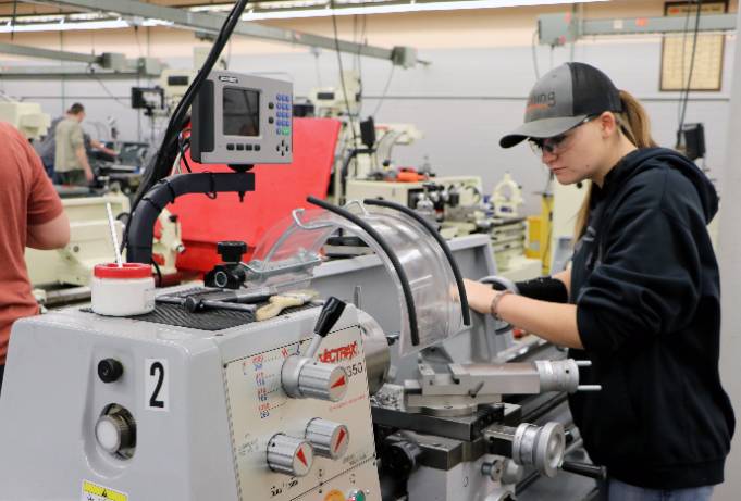 manufacturing student works on machinery